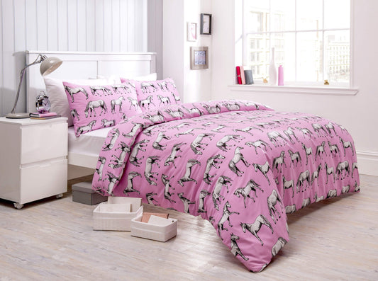 Pink bedspread with horse pattern on a bed in a bright bedroom.